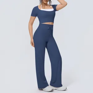 Detail view of a navy blue two-piece yoga set featuring short sleeve top and wide leg pants.