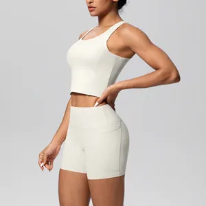 Zijprofiel van gebroken witte sportbeha en yogashorts met hoge taille en zakdetail