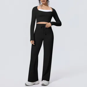 Detailed view of black two-piece yoga set with long sleeve top and wide leg pants