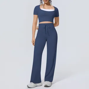 Full view of women's navy blue yoga set with short sleeve top and wide leg pants.