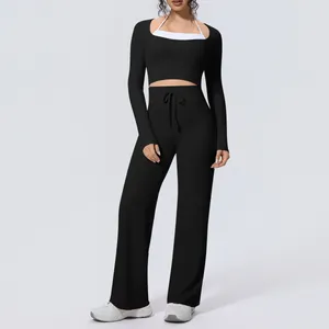 Full body view of women's black long sleeve yoga set with wide leg flare drawstring trousers