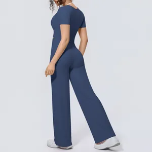 Rear view of women's blue two-piece athletic yoga set with crop top and wide-leg pants