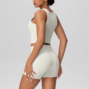 Zijaanzicht van crème yogaset met rugloze tanktop en korte broek met hoge taille
