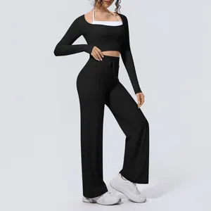Detail of black long-sleeve yoga set featuring high-waisted wide-leg gym pants for women