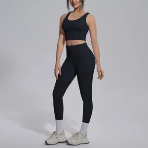 Woman posing in a black v-neck sports bra and matching high waisted yoga leggings.