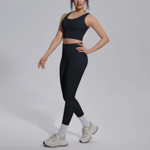 Full body view of a woman wearing a black V-neck yoga set with high-waisted leggings.