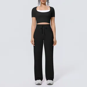 Black two-piece yoga set featuring cropped short-sleeve top and wide-leg pants