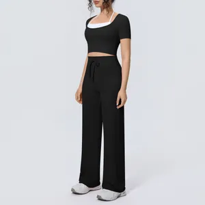 Two-piece black sports yoga set with short-sleeved halter top and wide-leg trousers