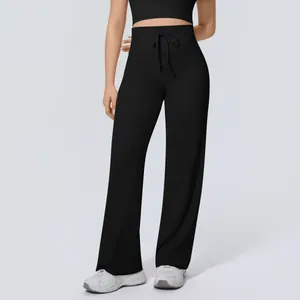 Detail view of high-waisted black wide-leg yoga pants with a functional drawstring tie.