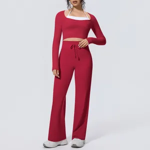 Full body front view of a red long-sleeve crop top and wide-leg yoga pants set on model