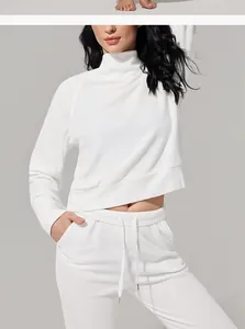 Detalle de conjunto deportivo blanco de punto gofre con cuello alto y joggers cómodos