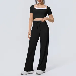 Close-up of a stylish black sports yoga set featuring wide-leg pants and a halter neck top.