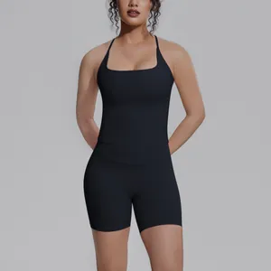 Model draagt zwarte sporttanktop met vierkante hals en strakke yogashortset