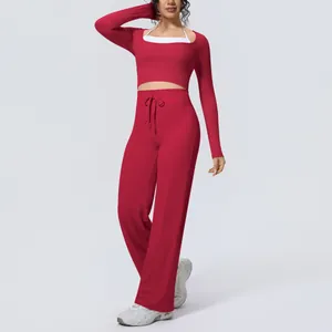 Detail view of a red long-sleeved yoga set with wide-leg pants and a white inner bra.