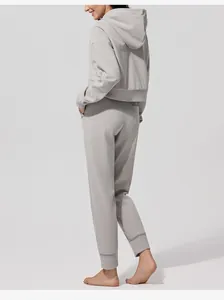 Vista posterior de un conjunto de chándal con capucha de pana gris para mujer en otoño