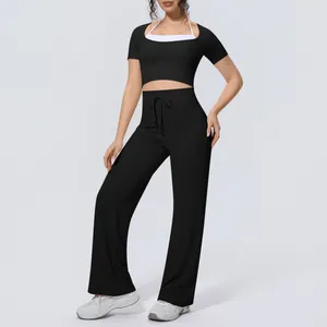 Full-length view of a sporty black and white yoga set with halter crop top and flared yoga pants