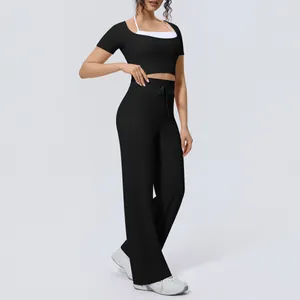 Women's two-piece black yoga set featuring a halter crop top and breathable wide-leg pants