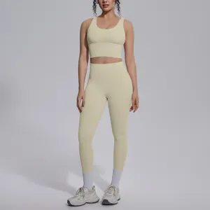 Full body view of a model wearing a beige seamless yoga set in a studio setting