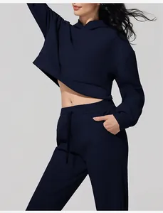 Detalle del conjunto de sudadera corta con capucha y joggers de pana azul marino en modelo