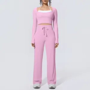 Front view of pink long-sleeve yoga set with high-waisted wide-leg pants for women