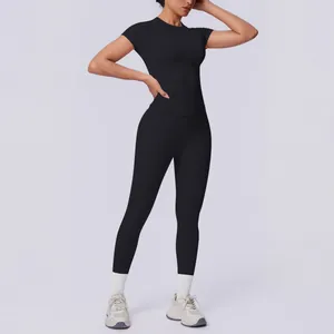 Sportliche Frau in schwarzem nahtlosem Yoga-Set aus Strick mit Kurzarm-Top und Leggings