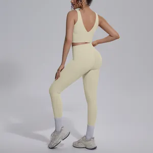 Back view of women's cream V-neck sports bra and high-waisted leggings yoga set.