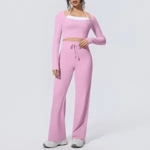 Pink cropped long-sleeve top and wide-leg yoga pants set with white halter inner.