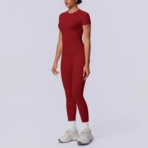 Detailansicht eines nahtlosen, burgunderroten Yoga-Sets mit Kurzarmshirt und Leggings