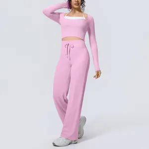 Detailed view of pink two-piece yoga set with long sleeve top and wide leg pants