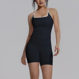 Detailweergave van de zwarte yoga-set voor dames met wit omzoomde sporttop en de short