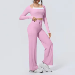 Pink long-sleeve crop top and wide-leg yoga pants set for Pilates and fitness.