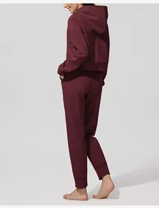 Vista posterior del conjunto de sudadera con capucha y pantalón jogger de pana granate para mujer