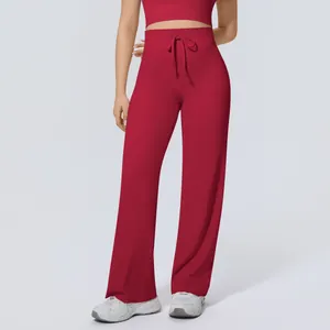Detail view of high-waisted red wide-leg yoga pants with adjustable drawstring waist.