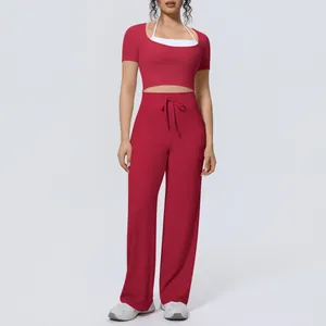 Professional studio shot of woman in red sports crop top and wide-leg yoga pants