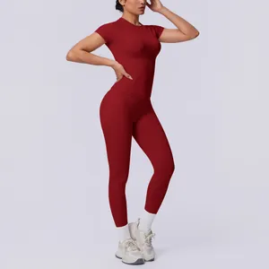Ganzkörperansicht eines Models in einem dunkelroten nahtlosen Yoga-Set im Fotostudio