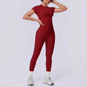 Ganzkörper-Detail eines nahtlosen burgunderroten Yoga-Sets mit Kurzarm-Oberteil und Leggings