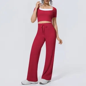 Two-piece yoga set featuring a red short sleeve crop top and matching wide leg pants