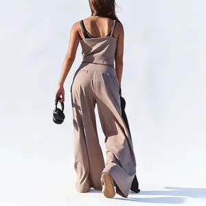Back view of woman in taupe yoga set with wide-leg pants and thin strap camisole detail