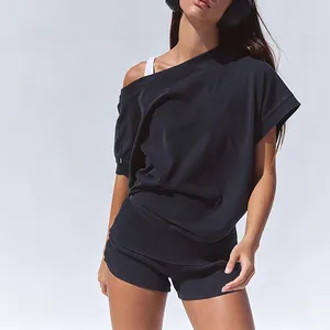 Detail of black off-the-shoulder sports set with loose T-shirt and mini shorts.