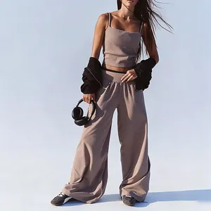 Full body detail of a woman wearing a brown yoga tank top and wide-leg sports pants