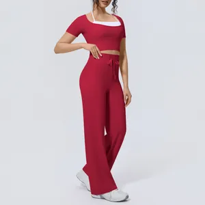 Red yoga set with halter neck crop top and high-waisted wide-leg athletic trousers.