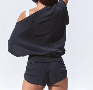 Detail back view of a black off-shoulder fitness top and slim sports shorts set