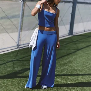 Close-up of blue yoga tank top and wide-leg sports pants outfit on outdoor court