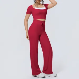 Two-piece red yoga set featuring halter neck crop top and high-waisted wide leg pants