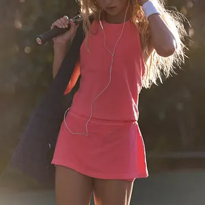 Close-up view of a pink fitness tank top and matching high-waist tennis skirt set on model