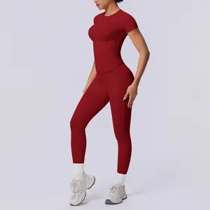 Nahtloses bordeauxrotes zweiteiliges Yoga-Set mit Kurzarm-Oberteil und Leggings.