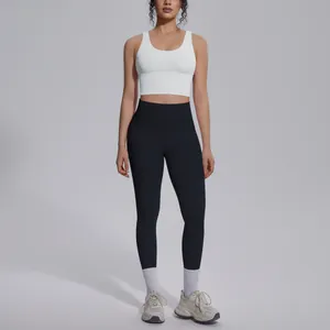 Detail view of women's white V-neck sports bra and high-waisted black yoga leggings