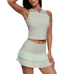 Two-piece mint green sports set featuring half-zip sleeveless top and pleated skirt