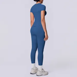 Rückansicht des nahtlosen blauen kurzärmeligen Yoga-Sets mit hochtaillierten Leggings im Studio.