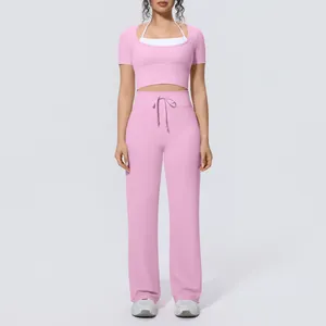 Detail view of women's pink yoga set featuring halter top and wide-leg trousers